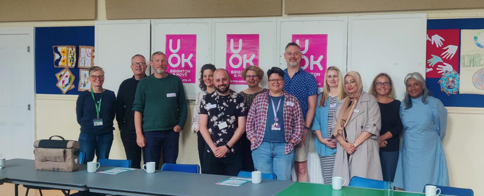 UOK Partners representatives stand in a group against a backdrop of UOK poster.