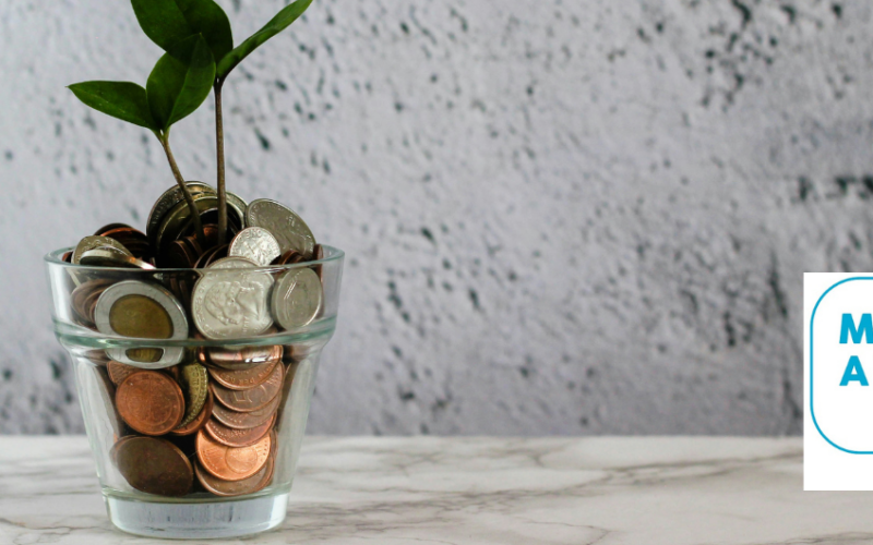 A glass full of coins with a plant growing at the top to depict growing saving with good financial knowledge.
