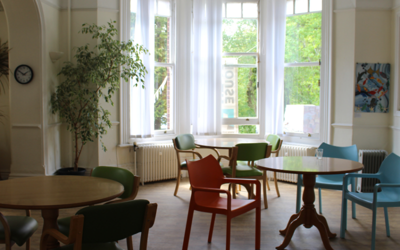 an image of staying well service room at wellbeing hub preston park, with chairs and tabled laid in an aesthetic, calming room