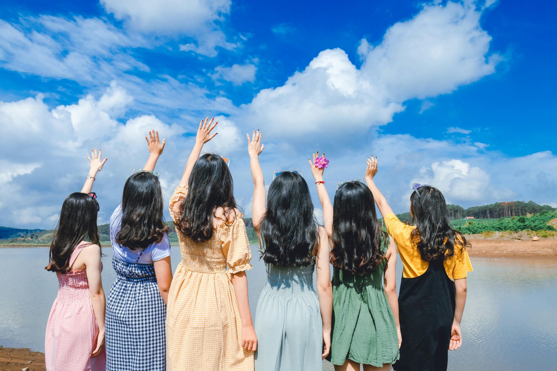 a group of women spreading their hands towards a cloudy sky signifying they want to and should reach out for help if needed.