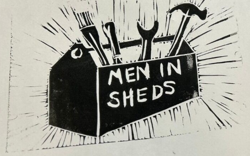 A sketched, monochromatic image of a box with tools with 'Men in Sheds' written on the side of the box.